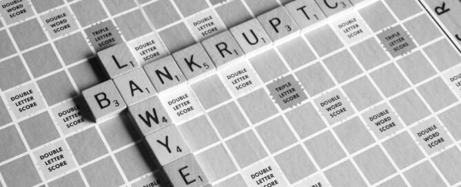 Scrabble board displaying the words "LAWYER" and "BANKRUPTCY" intersecting at the letter "R".