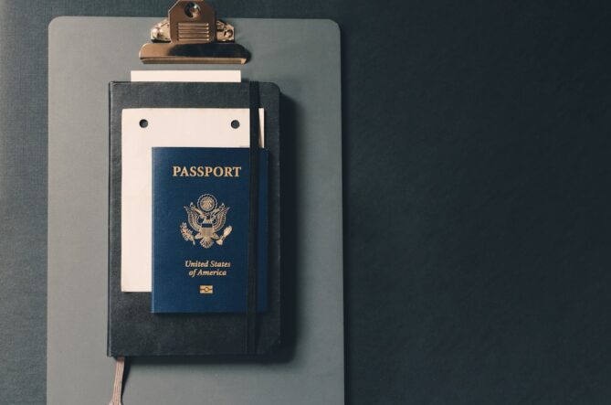 A US passport, notebook, and document are neatly arranged on a clipboard.